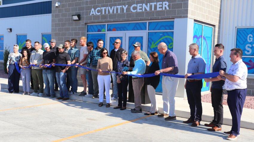 Scott Ramsdell (center in blue) cuts the ribbon Saturday night to officially open the new gymnasium and expanded Boys and Girls Club of Moody County. The Ramsdell family, the project’s lead donors, were celebrated alongside hundreds who came to recognize the growth of a vital community resource made possible through strong local partnerships. Others invited to be a part of the ribbon cutting ceremony were Boys and Girls Club of Moody County officials, and anyone else who may have played a part in the construction process.