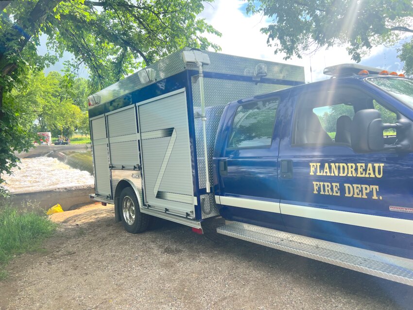 The Flandreau Fire Department Rescue Truck sat parked near the Big Sioux River on July 5th, as fast-moving waters near the dam made the search for a missing woman a difficult and dangerous task. Despite the beautiful summer day, the scene was anything but peaceful, with rescue crews on high alert, working to locate Jamie White, who was believed to have either fallen or jumped into the river early that morning. A large amount of rain had fallen north of Flandreau the previous weekend and all that water had come downstream by the holiday weekend.