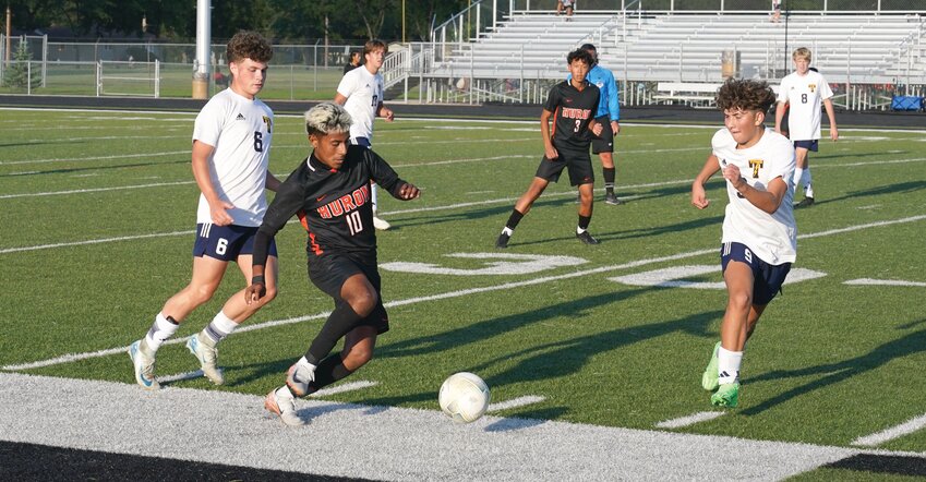 Huron’s Ronaldo Pineda plays the ball as Hudson Hadrick (6) and Kasen Groeneveld (3) of Tea Area defend during their game Thursday at Tiger Stadium.