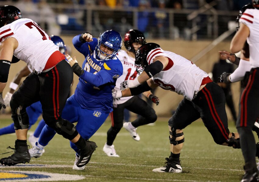 Kobe Clayborne (94) of the South Dakota State Jackrabbits gets a step past Jordan Larsen (73) of the South Dakota Coyotes at Dana J. Dykhouse Stadium on Oct. 25 in Brookings.