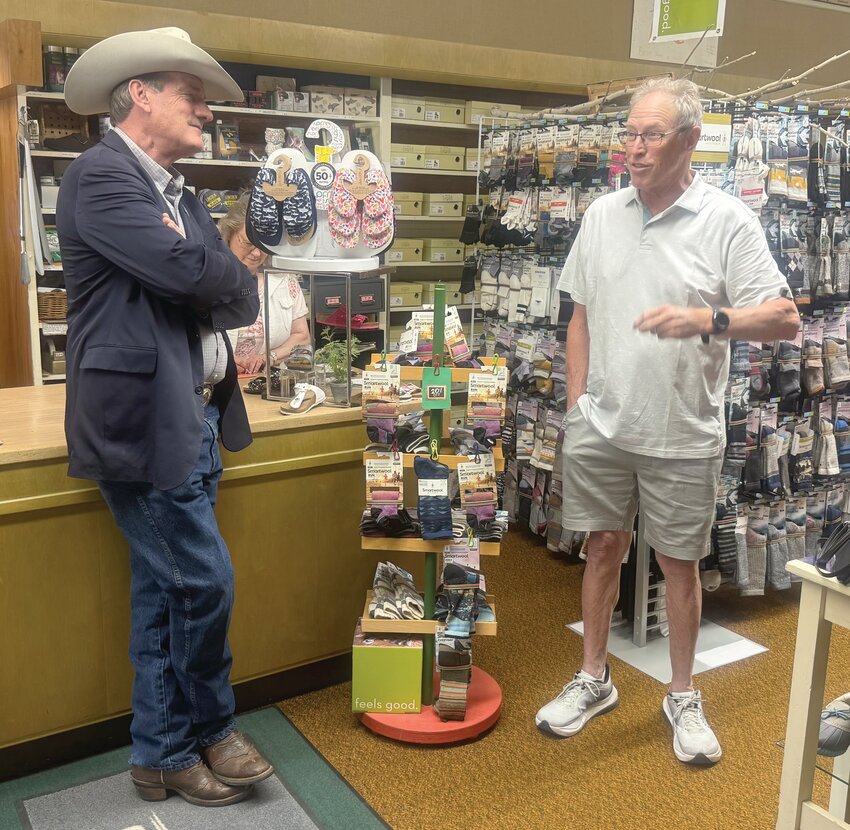 South Dakota Governor Larry Rhoden, left, speaks with business owner Bush Fullerton at Potter’s Shoes on Wednesday.