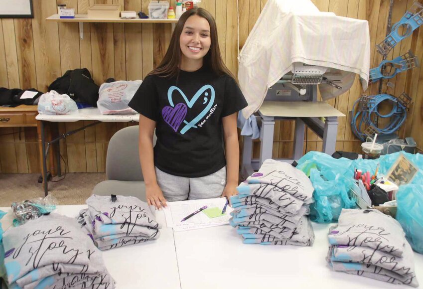 Huron High School senior Cadence Kogel sorts through stacks of the t-shirts that she worked with PB Sports to produce for Monday’s Day of Hope in Huron.