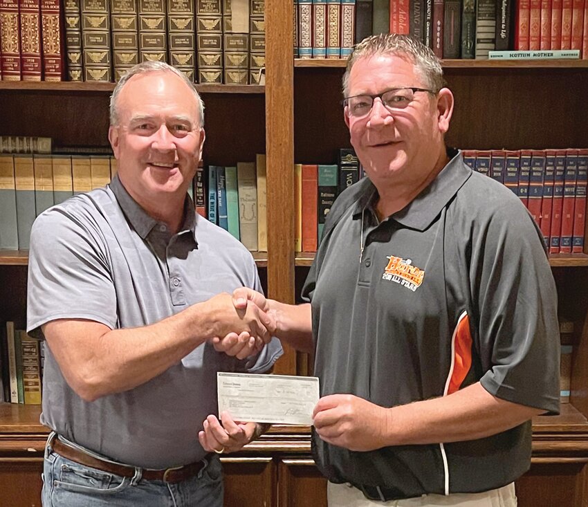 Todd Larimer, left, presents a check from the Bob Bushman estate to Matt Wenzel of Huron Baseball.