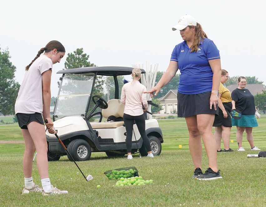 South Dakota State University women’s golf coach Ericka Schneider provides instruction to Taylor Sorben during a golf clinic held Wednesday at Huron Country Club.