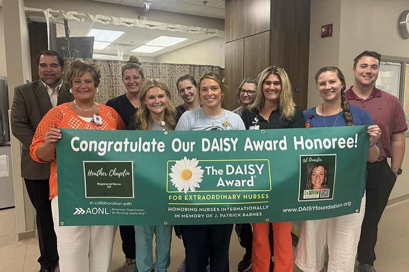 Heather Chaplin, RN, BSN, poses for a photo with colleagues following receipt of the DAISY Award.